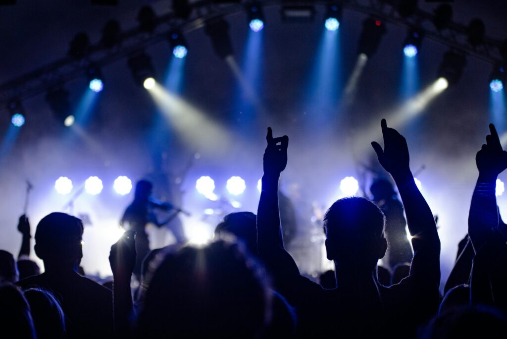 audience enjoying a live performance with dramatic lighting at night. freelance event photographer